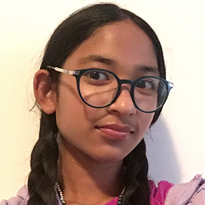 Élève aux longs cheveux tressés portant des lunettes, un chandail à capuchon mauve et un t-shirt rose devant un fond pâle uni.